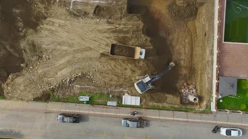 Aerial View of Excavator Loading Truck on Construction Site