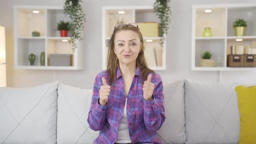 Woman Giving Thumbs Up and Clapping on Couch