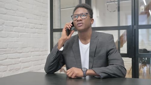 Young African Man Talking on phone in Office