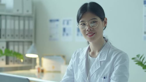 Portrait of Young Asian Female Doctor with Laptop in Clinic