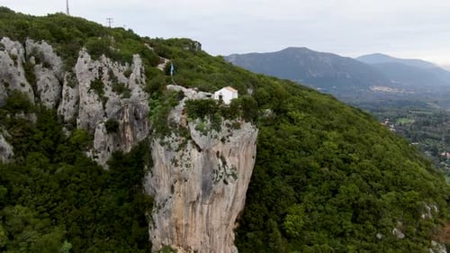 Epic aerial drone orbit of Agios Stylianos, a tiny white chapel
