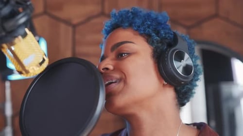 Young African American Woman Singer Standing Near Microphone in Recording Studio
