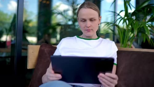 Young Woman Using Tablet in Outdoor Cafe