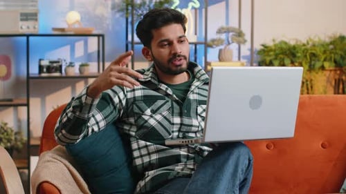 Man Video Calling on Laptop in Living Room