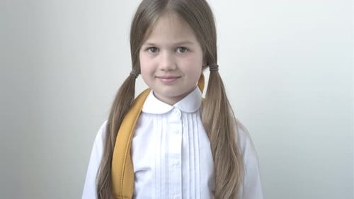 Portrait of Cute Smiling School Girl in White Tshort on Gray Background
