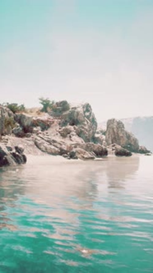 Vertical Video of Large Rock Island in the Middle of the Sea Water