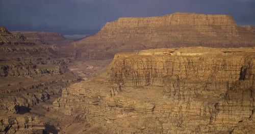 Majestic Rock Formations Rise Above a Rugged Desert Landscape at Sunset