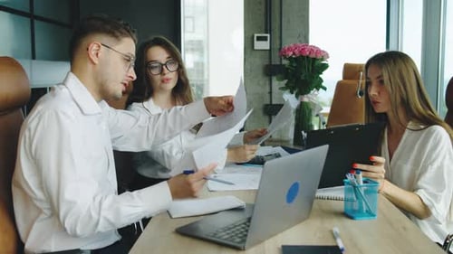 Business Meeting with Colleagues Discussing Project Details in a Modern Office Setting During