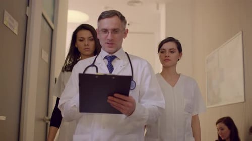 Doctors Walking and Talking in Hospital Corridor