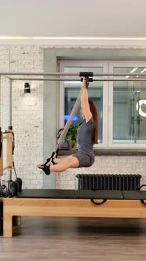 Woman Performs Pilates Leg Exercises in Fitness Studio