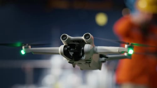 Drone Hovering with Construction Workers Blurred in Background