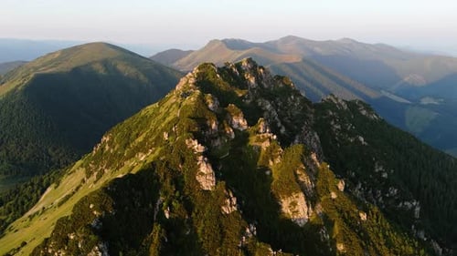 Aerial Drone Orbit Shot Around a Majestic Mountain Peak at Sunset