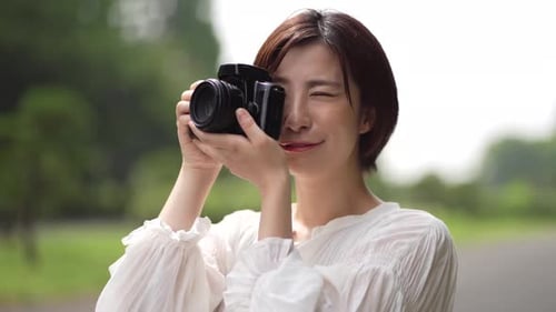 Woman Taking Photos in a Green Park