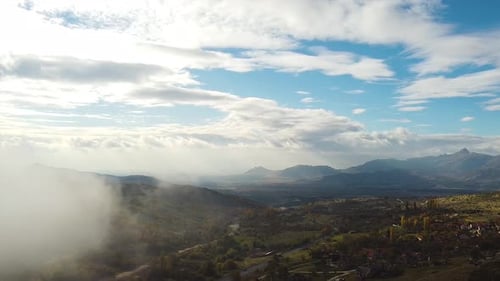 Aerial shot of a beautiful landscape going into the fog. Misty day.