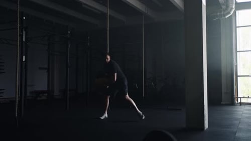 Professional Sportsman Throwing Heavy Ball To Wall Training In Fitness Club Powerlifting
