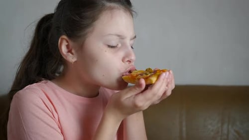 Girl Eating Pizza Slice Close Up Indoors