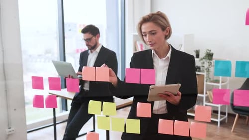 Business Professionals Brainstorming Ideas Using Sticky Notes on Board