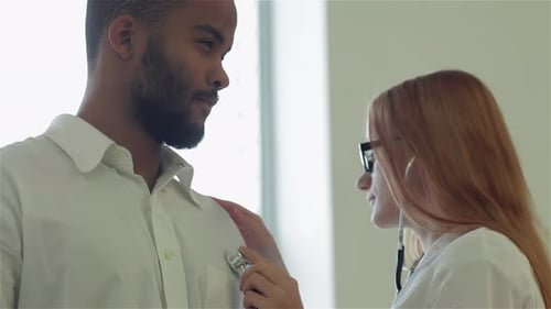 Doctor Examining Young Adult Male with Stethoscope