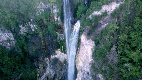 Blick aus der Vogelperspektive: Grüne Natur des Waldes, Wasserfall und feuchter Berg im Fluss