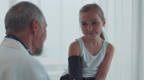 Child Having Blood Pressure Measured by Doctor in Clinic