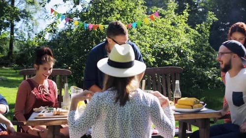 Leisure, Party, People And Holidays Concept - Happy Friends Gathering For Dinner At Summer Garden