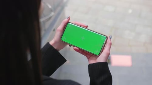 Young Woman Hands Hold Smart Phone with Horizontal Green Screen Outdoors Urban City Internet Mobile