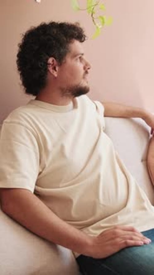 Man Sitting on Couch Looking Out Window