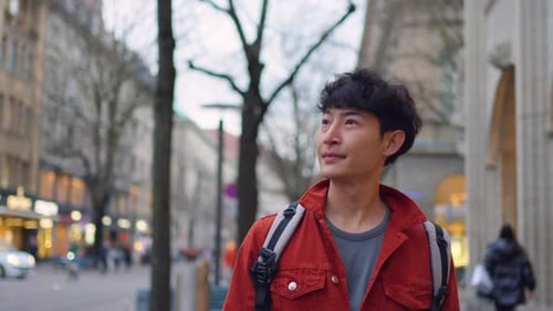 Asian attractive man backpacker walking around beautiful road in city.