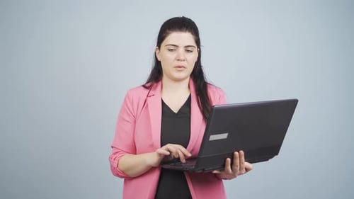 Business woman looking at laptop with tired expression.