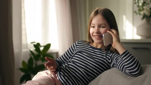 Girl Chatting on Phone While Reclining on Sofa
