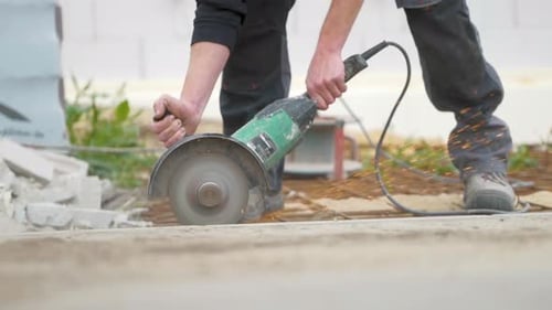 Construction Worker Cuts Rebar with Angle Grinder