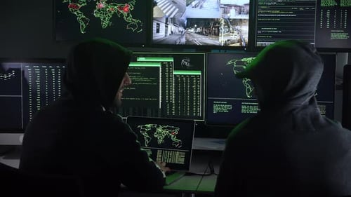 Hooded Hackers Working at Computers at Night