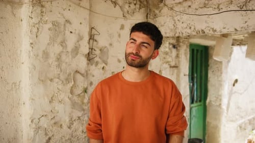 Young Man Contemplating with a Lightbulb in Rustic Setting