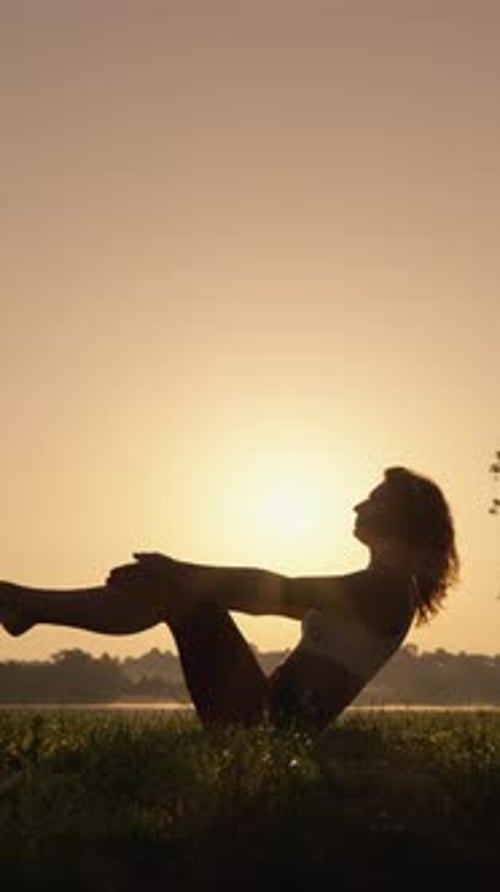 Woman Breathing in Fresh Morning Air at Sunrise Near Lake Introducing and Performing Yoga for