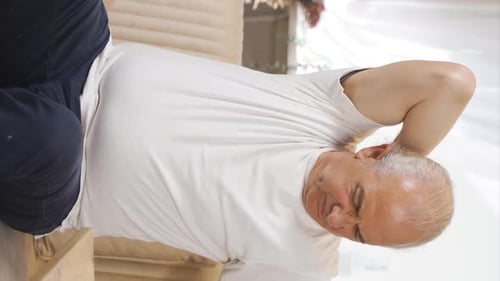 Vertical video of Sick old man with back pains.