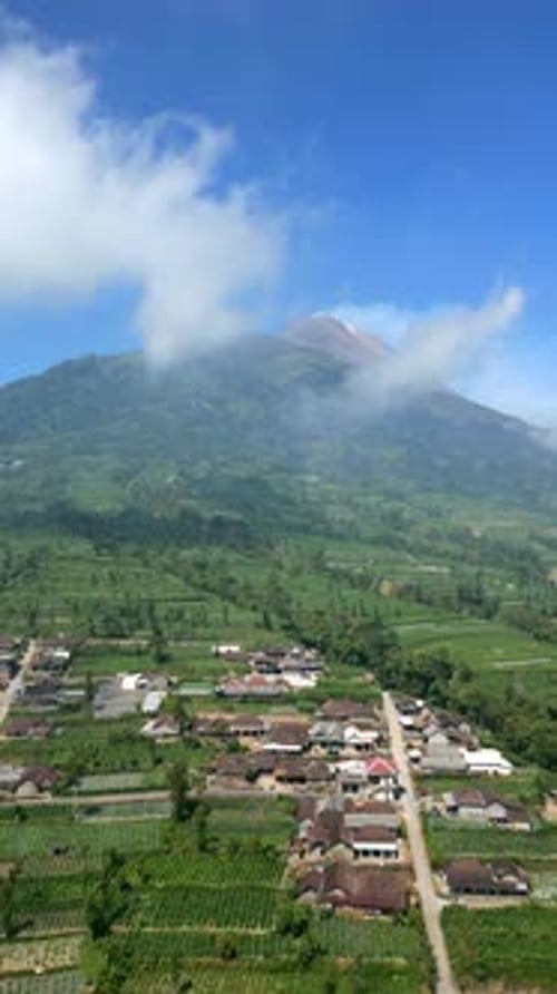 Luftaufnahme des aktiven Vulkans Merapi und des malerischen Dorfes an seinem Hang, Indonesien