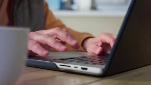 Senior Person Typing on Laptop at Home