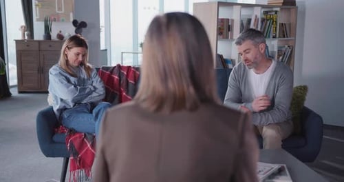 Erwachsenes Ehepaar, das mit einem Berater für psychische Gesundheit im Büro sitzt, missbraucht, beleidigte Frau, Ehefrau