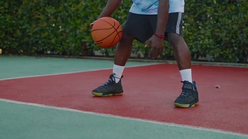 Un homme afro-américain s'entraîne avec un ballon de basket pour améliorer ses compétences en dribble
