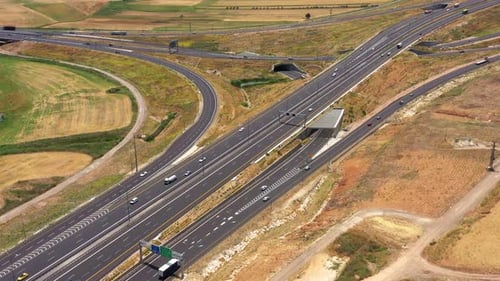 Traffic on a multi lane Highway surrounded with lush green nature.