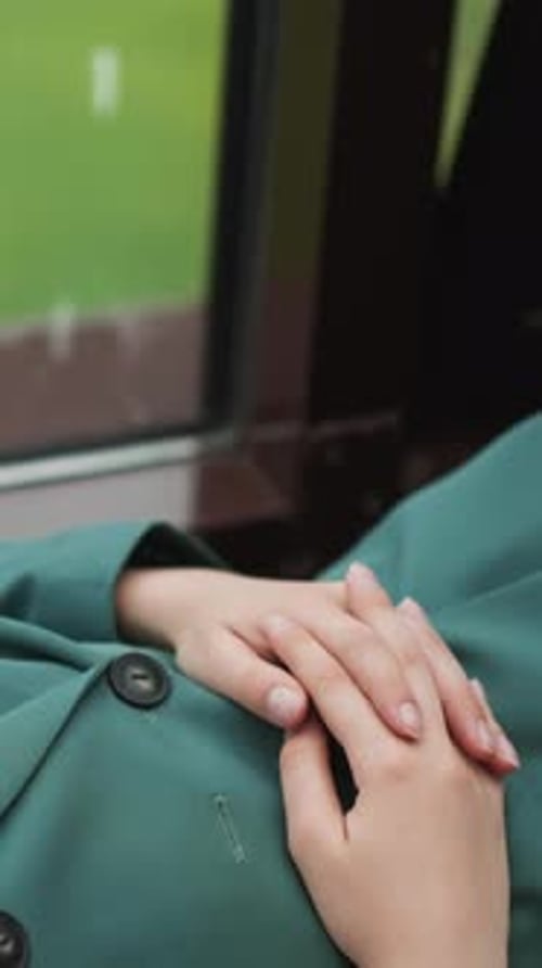 Hands Resting on a Green Coat Indoors