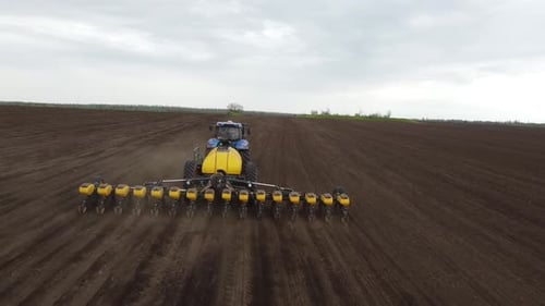 Blue tractor OA working on the field in Ukraine