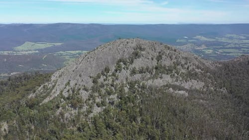 Craggy barren Sugarloaf peak rises starkly above surrounding valley