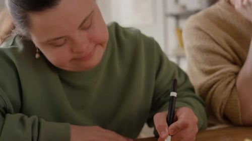 Woman Draws with Friend Indoors Daytime