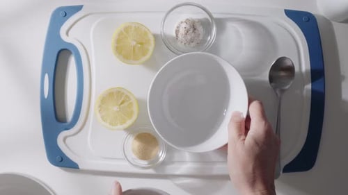 Hands Stir Greek Yogurt in a Bowl While Preparing a Creamy Homemade Sauce with Fresh Ingredients