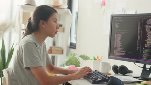 Asia girl IT development programmer typing on keyboard coding programming fixing data code.