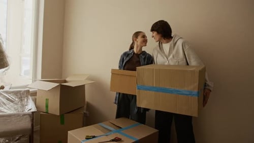 Junges Paar hält Pappkartons beim Einzug in die Wohnung in der Hand