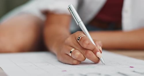 Woman Writing on a Calendar with a Pen