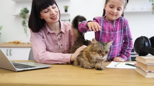 Woman and Child Petting Cat at Kitchen Table