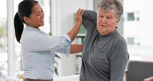 Senior Woman Exercising with Weights in Physical Therapy